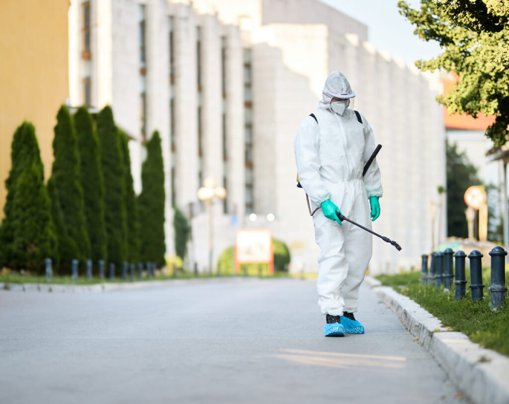 hombre-traje-protector-desinfectando-calles-ciudad