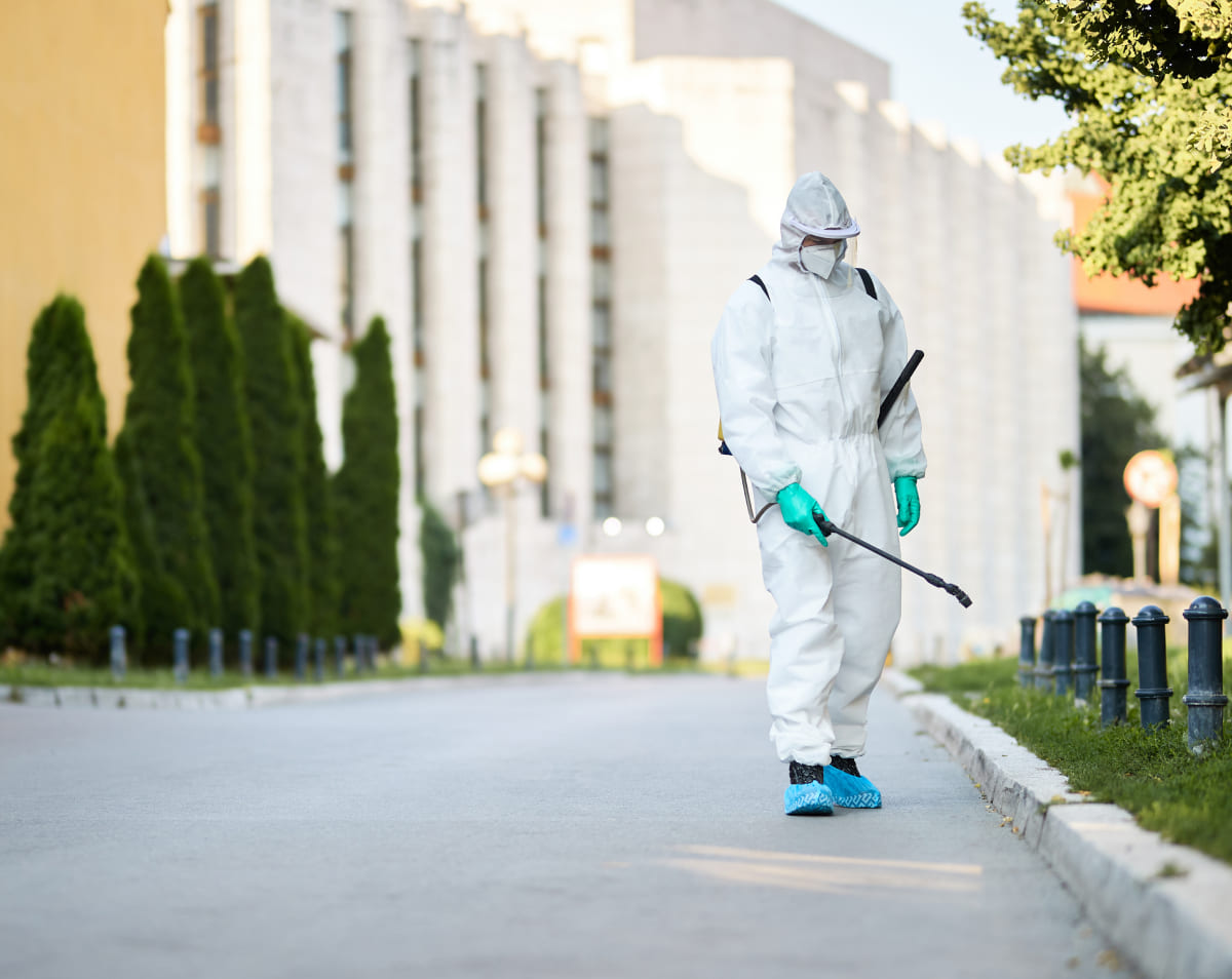 hombre-traje-protector-desinfectando-calles-ciudad